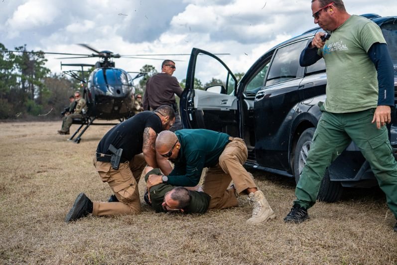 Students running a ground-control and extraction drill beside a vehicle
