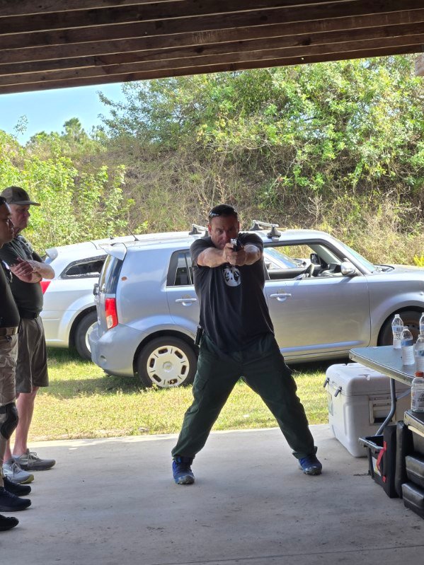 Student holding a shooting stance under instructor supervision